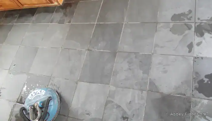 Damaged slate floor with flaking edges and abraded high spots