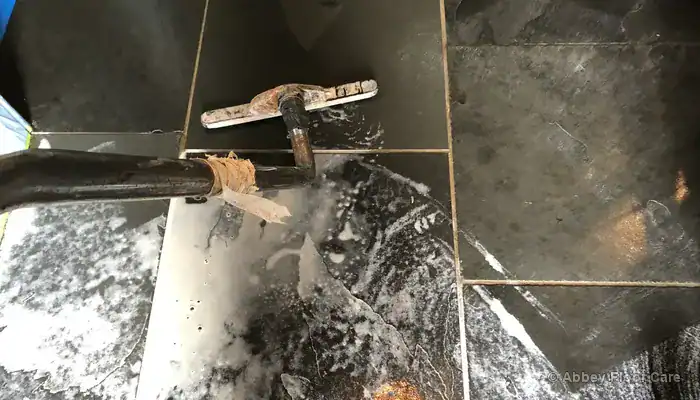Slurry extraction removing residue from textured slate flooring